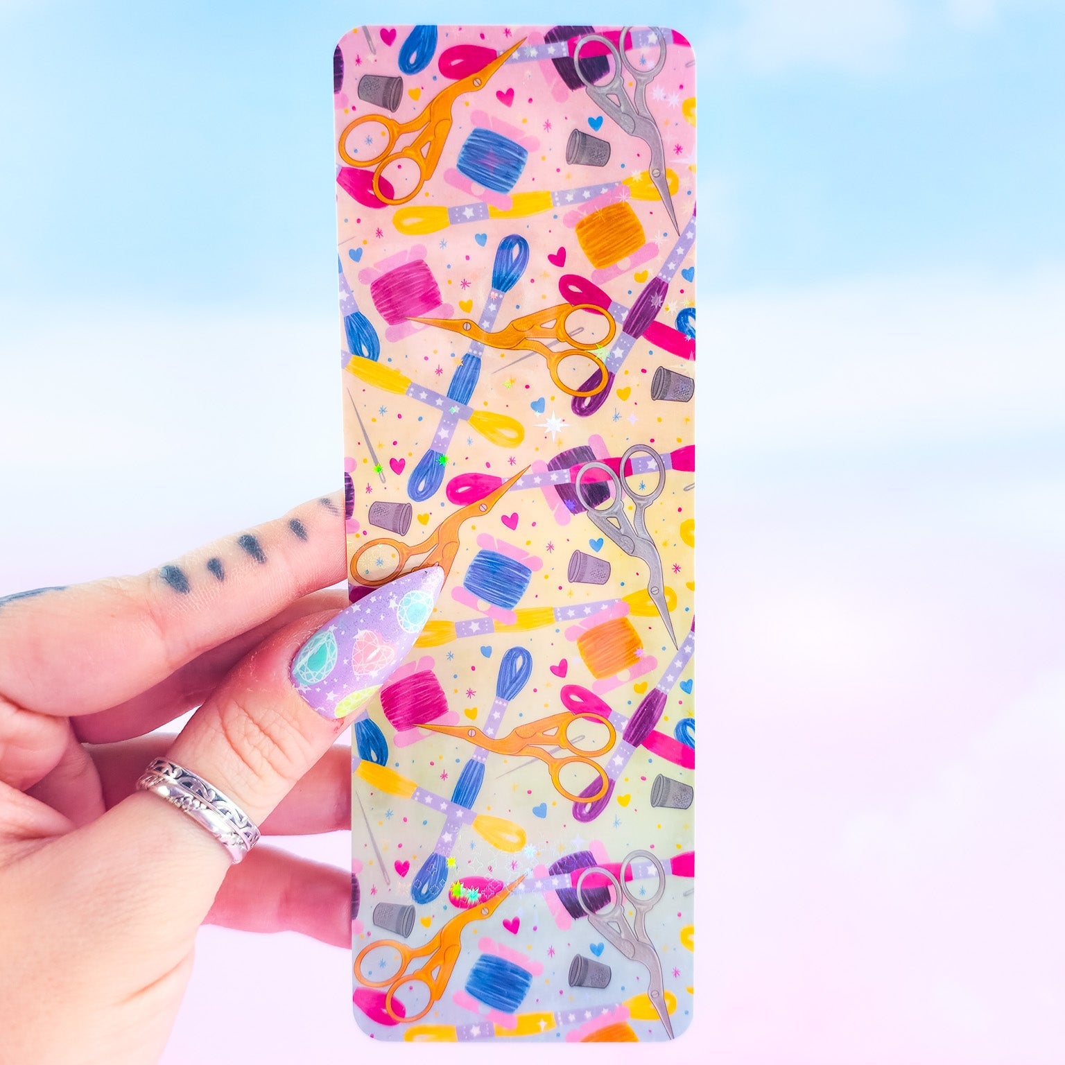 Embroidery holographic bookmark – colorful sewing pattern with stork scissors, floss skeins, and thimbles, laminated handmade book accessory