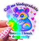 Colorful sticker with a cartoon possum holding a heart and text that says "Call me biodegradable because I break down easily" on a light pink background