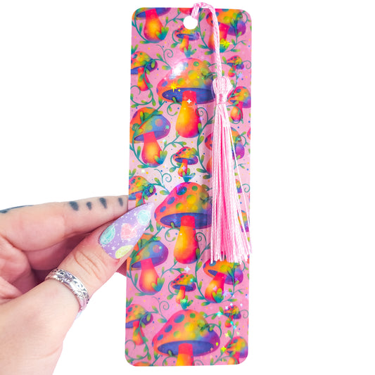Rainbow mushroom holographic bookmark with pink tassel, handmade and glossy, shown in hand