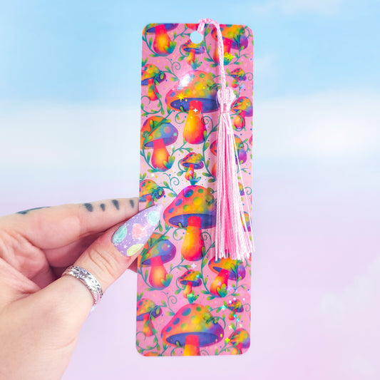 Rainbow mushroom holographic bookmark with pink tassel, handmade and glossy, shown in hand