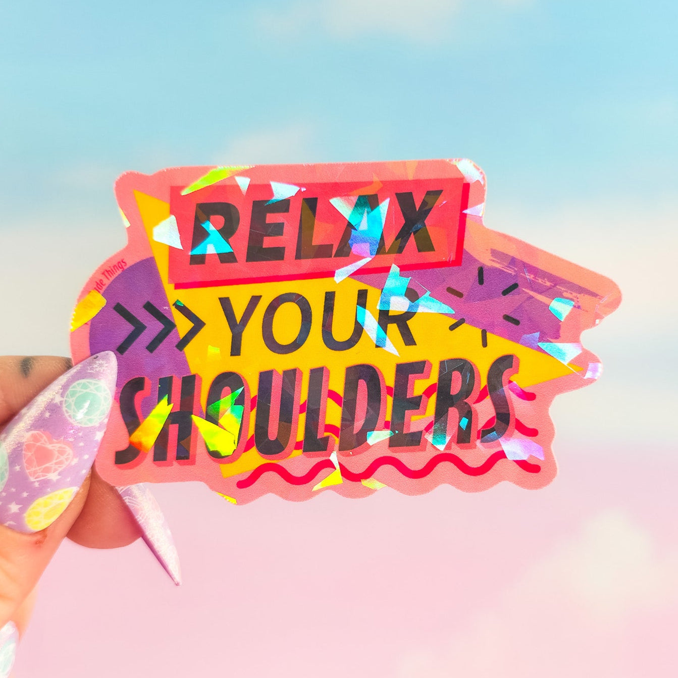Colorful card with 'Relax Your Shoulders' text held by a hand against a blurred background