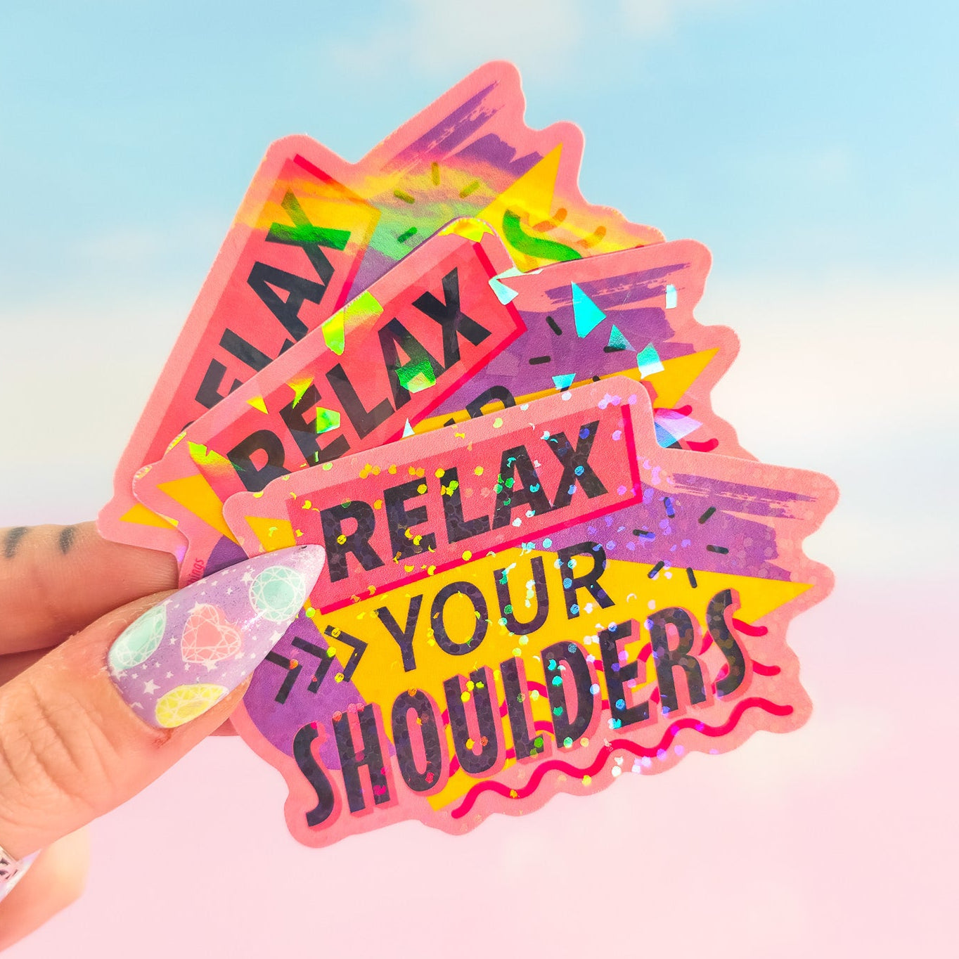Colorful 'Relax Your Shoulders' stickers held by a hand with a blurred background