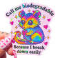 Colorful sticker with a cartoon possum holding a heart and text that says "Call me biodegradable because I break down easily" on a light pink background